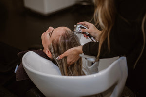 woman getting hair washed in salon bowl