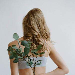 blonde woman holding greenery behind back