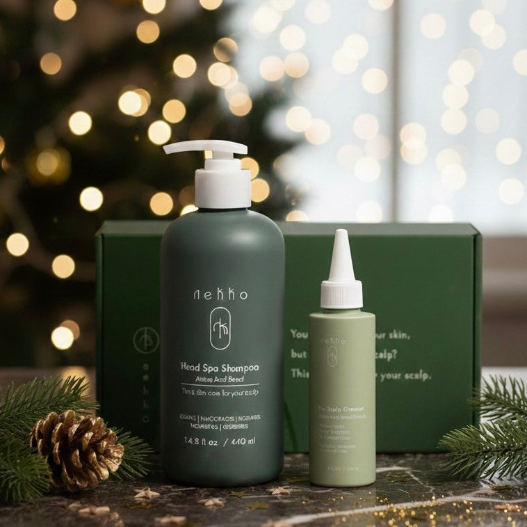 Two haircare bottles with a green box on a decorative surface with blurred lights in the background